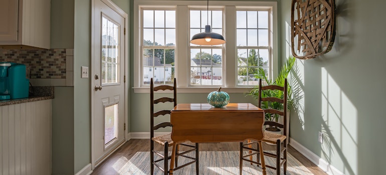 Chairs and a table in a room with big windows