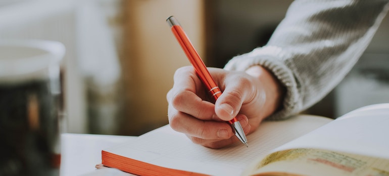 A person writing down a plan for moving to Toronto