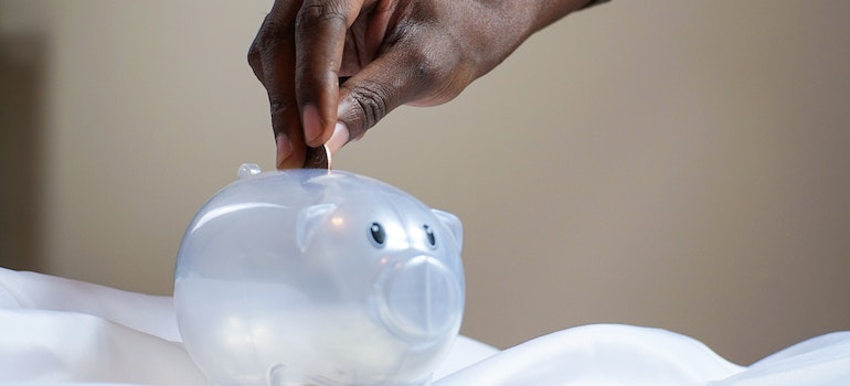 man putting money in a piggy bank