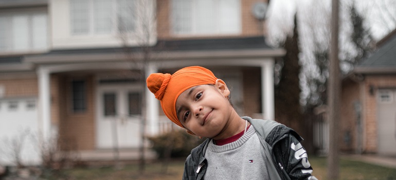 a kid in front of a home 