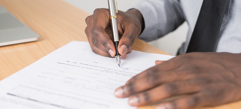 a man signing paperwork 