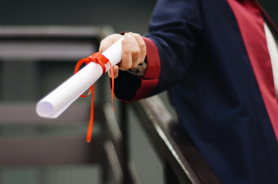 a graduate holding his diploma