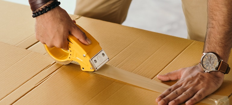 a man who knows how you move your art studio in Toronto packing a moving box 