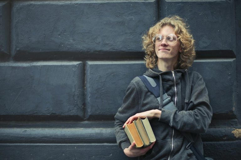 a young man holding books