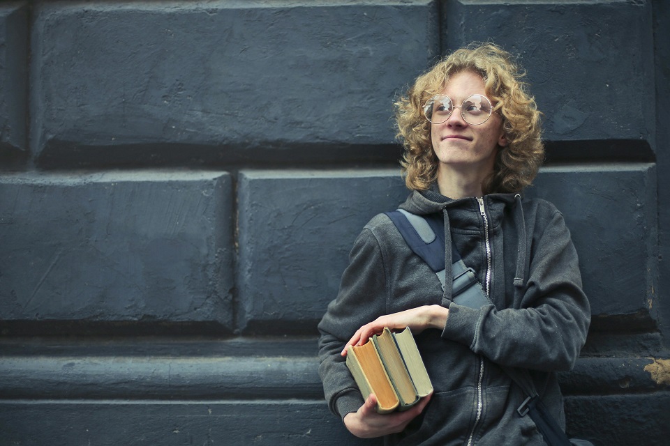 a young man holding books