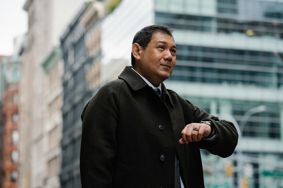 a man looking at watch in the middle of one of the common moving day in Toronto