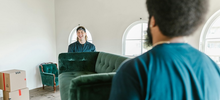 movers trying to prepare bulky furniture for moving
