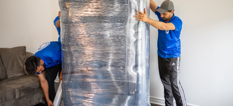 movers wrapping an item