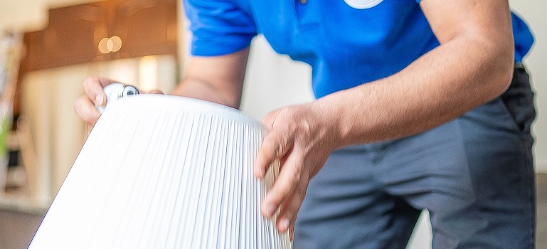 a worker from a Georgina moving company packing a lamp