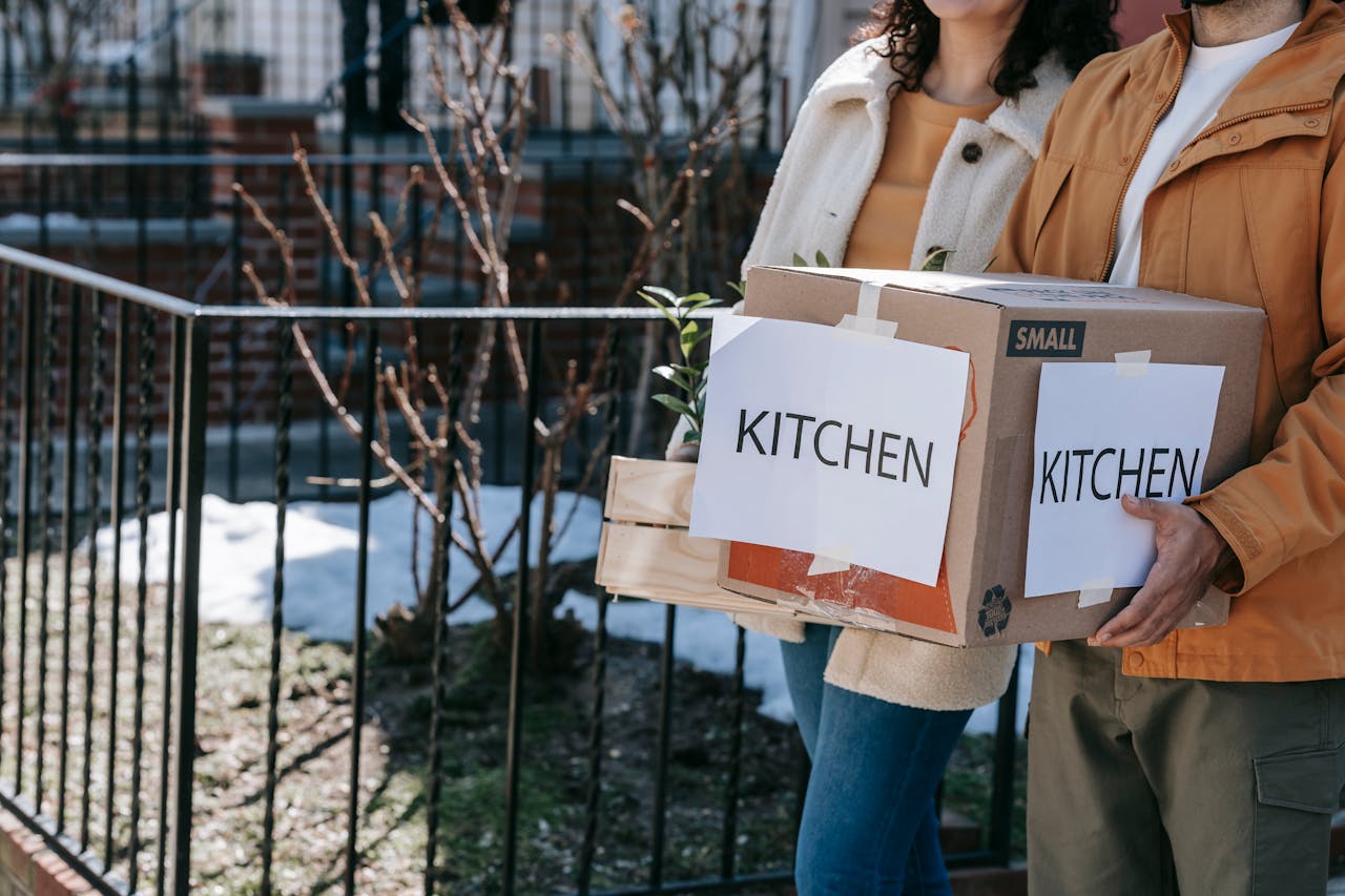 a couple carrying moving boxes