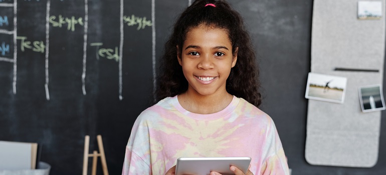 a girl smiling in front of a black board