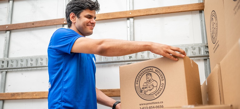 one of the Halton Region movers packing a moving box 