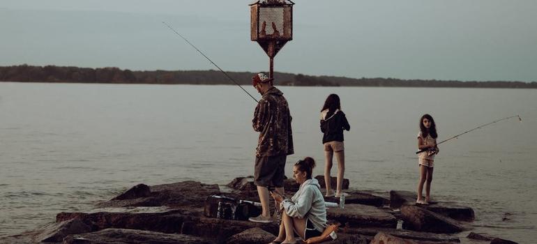 Family fishing by lakeside at dusk