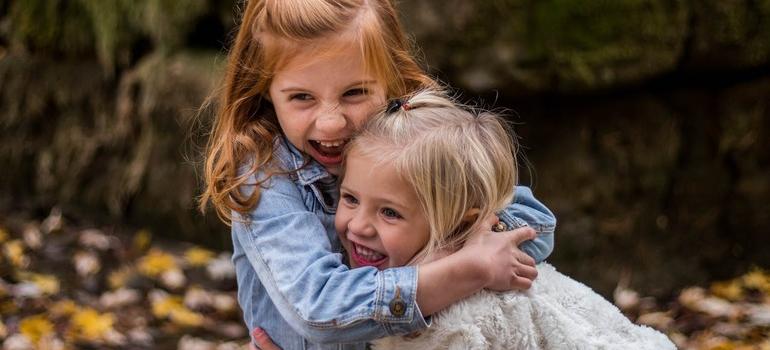 Young sisters hugging outdoors in one of the top Ontario locations for expecting parents