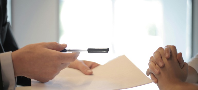 a man offering a pen to someone