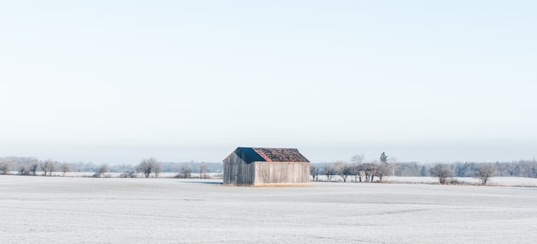 Snow-covered field with a solitary barn, a perfect setting for aspiring farmers moving to Bardford