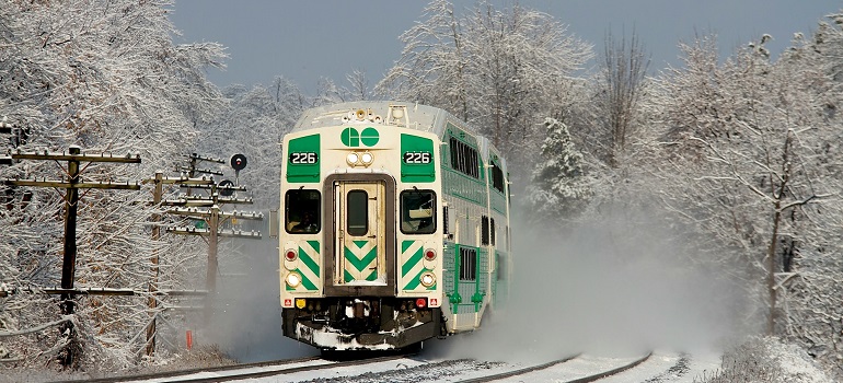 Snow-covered train traveling through winter scenery, which is one of the Commuting options in Vaughan