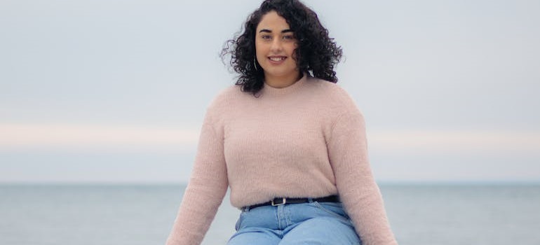 a girl who is aware of all the facts you didn't know about Ajax sitting near a body of water 
