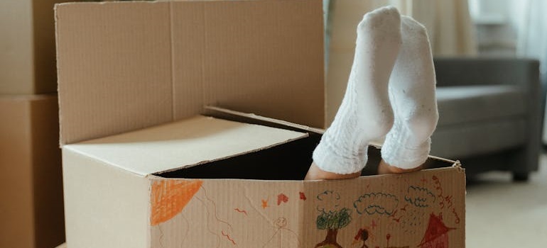 a kid hiding in a moving box