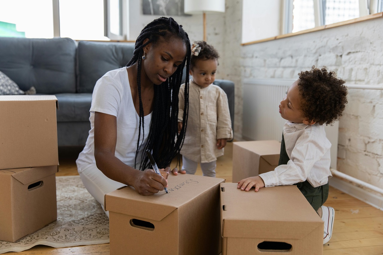 Mother and child labeling moving boxes when moving from Oakville to Mississauga with kids