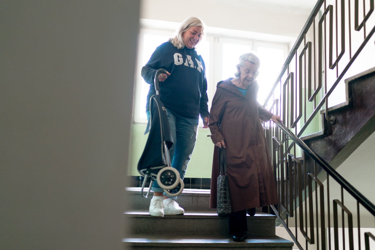 Seniors navigating stairs with support.