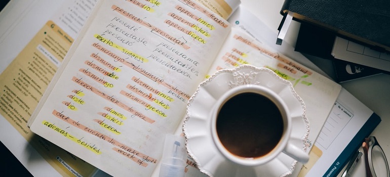 coffee cup next to some notes