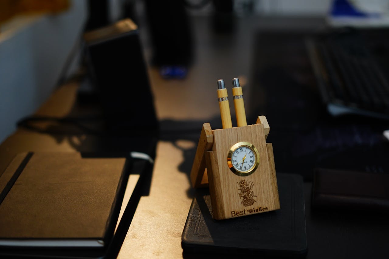 Desk with wooden clock and yellow pencils.