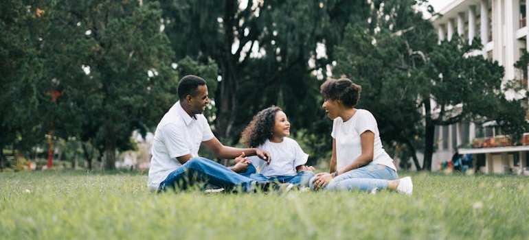 Family sitting on grass in a family-friendly suburban neighborhood park