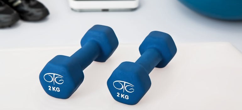 lightweight dumbbells of a someone who is peparing gym equipment for storage